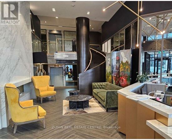A real estate office with a reception desk and two yellow chairs.