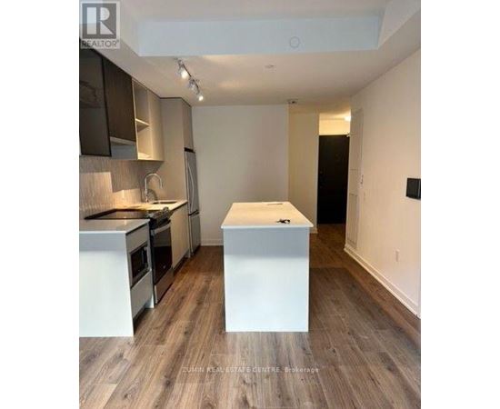A kitchen with a white island in the middle of the room.