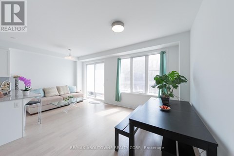 A well-lit, spacious living room with a dining table and chairs.