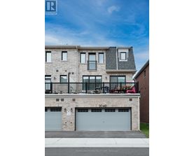 A multi-story building with a balcony and garage doors.
