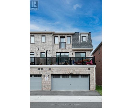A multi-story building with a balcony and garage doors.