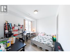 A bedroom with a bed, desk, and chair.