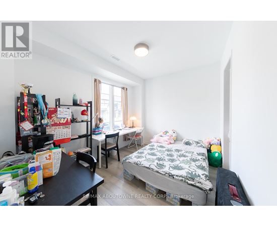 A bedroom with a bed, desk, and chair.