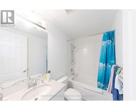 A white bathroom with a blue shower curtain.