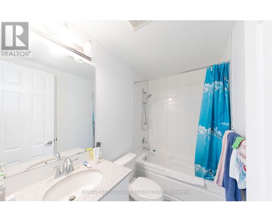 A white bathroom with a blue shower curtain.