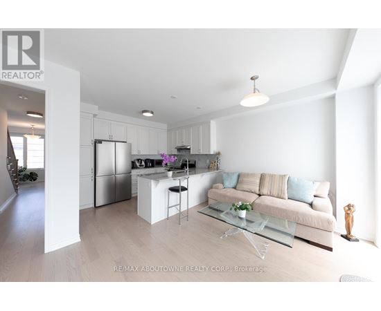 A modern kitchen with a bar stool and a glass table.