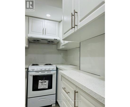 A white kitchen with a stove and cabinets.