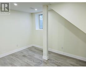 A room with a window and a wooden floor.