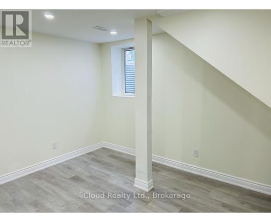A room with a window and a wooden floor.