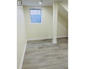 A room with wooden flooring and a window with blinds.