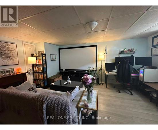 A living room with a couch, a coffee table, a television, and a bookshelf.