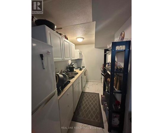 A kitchen with white cabinets and a black stove top.