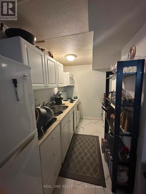 A kitchen with white cabinets and a black stove top.