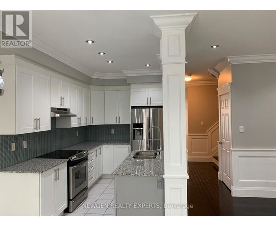 A kitchen with white cabinets and a black countertop.