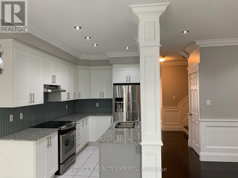 A kitchen with white cabinets and a black countertop.