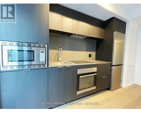 A modern kitchen with a stainless steel refrigerator and microwave.