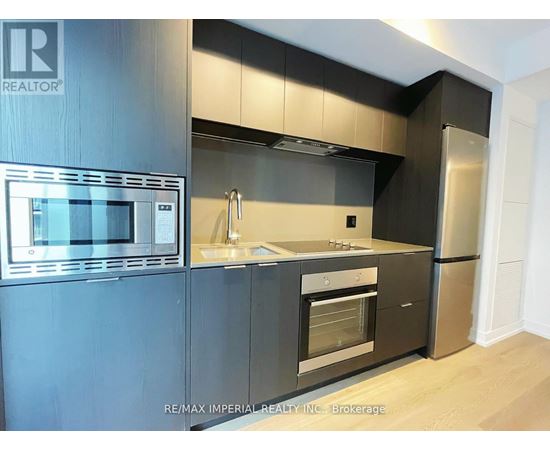 A modern kitchen with a stainless steel refrigerator and microwave.
