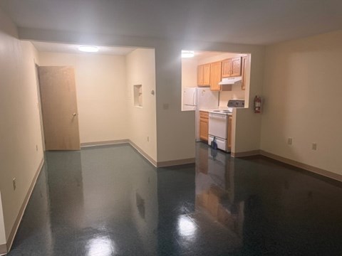 A kitchen area with a refrigerator, cabinets, and a microwave.
