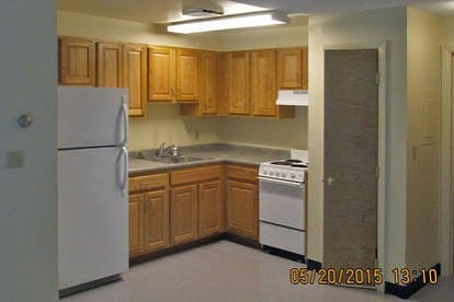 A kitchen with wooden cabinets and white appliances.