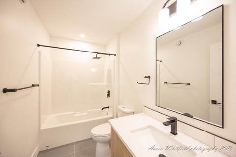 A white bathroom with a toilet, sink, and bathtub.