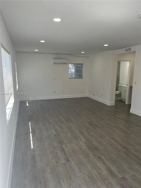 A spacious room with a grey floor and white walls.
