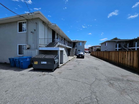 A street view of a residential area with houses on both sides and a car parked in the middle.