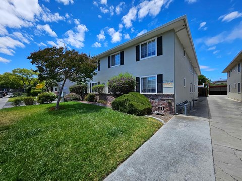 A house with a well-maintained lawn and a clear sky.