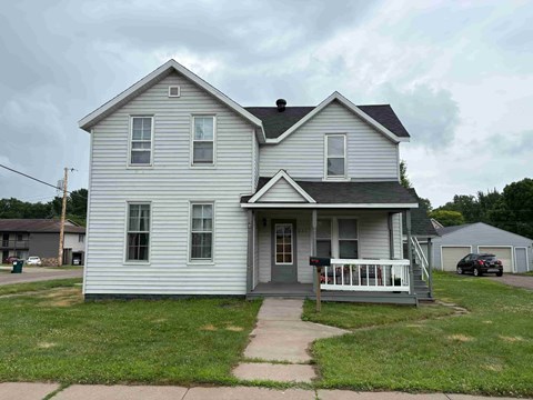 A two-story house with a grey front porch.