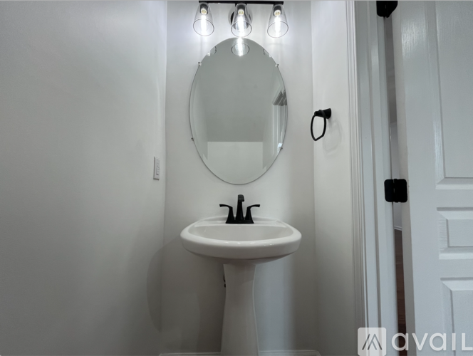 A white sink with a round mirror above it.