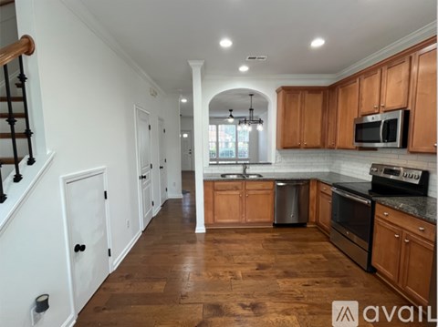 A kitchen with wooden cabinets and a stainless steel dishwasher.