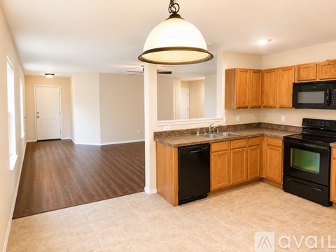 A kitchen with wooden cabinets and black appliances.