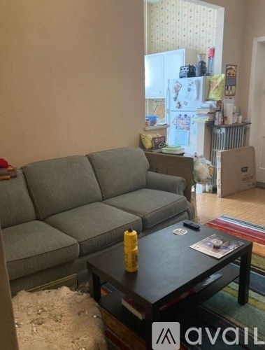 A grey sofa sits in a living room with a table in front of it.