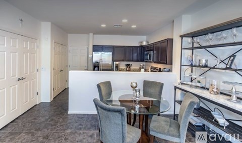 A modern kitchen with a dining table set for two.