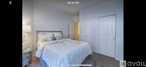 A bedroom with a bed and a nightstand.