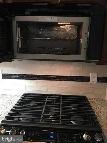 A black oven with a stove top and a tray of food in it.