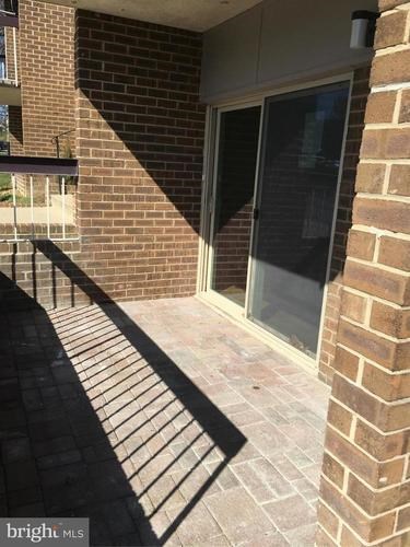 A brick building with a glass door and a metal railing.