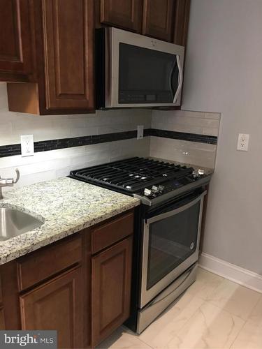 A kitchen with a stove top oven and microwave above it.