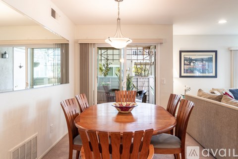 A dining room with a wooden table and chairs.