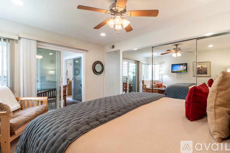 A bedroom with a large bed and a ceiling fan.