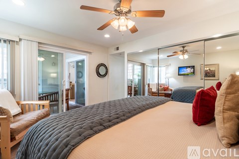 A bedroom with a large bed and a ceiling fan.