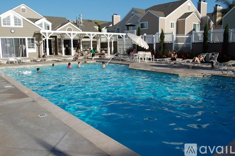 A group of people are enjoying a sunny day at the pool.