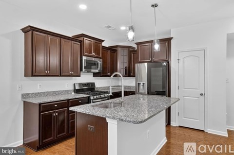 A kitchen with brown cabinets and a granite countertop.