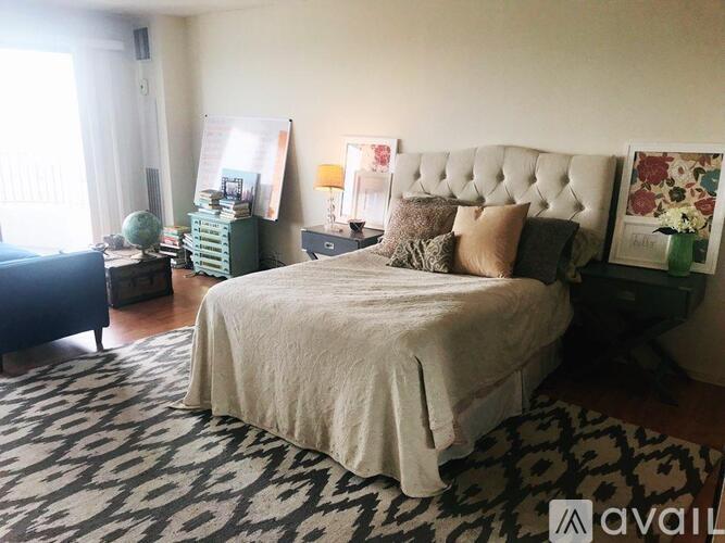 A bedroom with a large bed and a patterned rug.