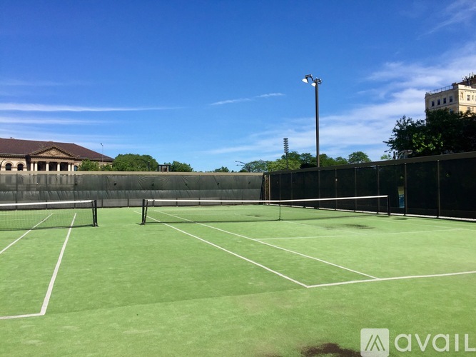 A tennis court with a net and a building in the background.
