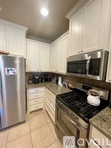 A kitchen with a stove top oven and a refrigerator.