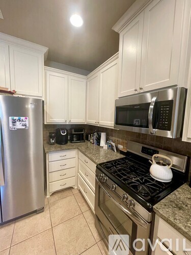 A kitchen with a stove top oven and a refrigerator.