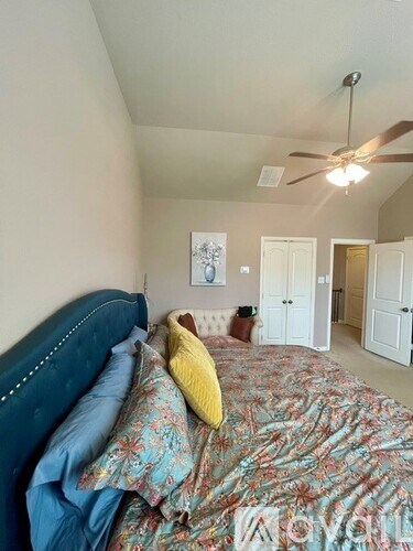A bedroom with a bed and a ceiling fan.