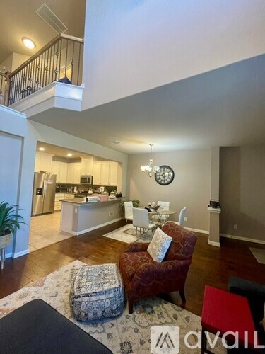 A living room with a red chair and a patterned ottoman.