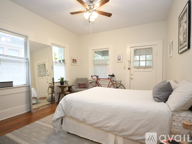 A bedroom with a large bed and a bicycle in the corner.