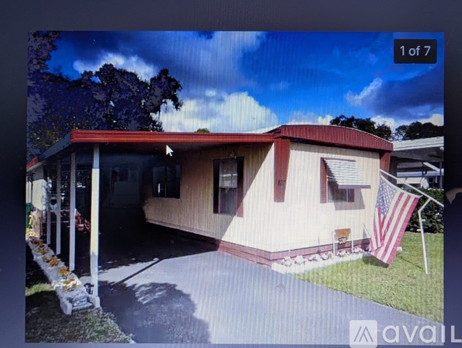 A house with a red roof and a flag on the lawn.